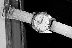 Vintage wristwatch with leather strap on a plain background